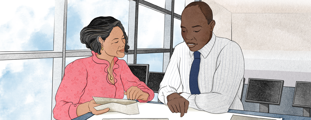 Mastering_Mentoring Mentor and mentee review documents together during a one-to-one mentoring session in a bright office